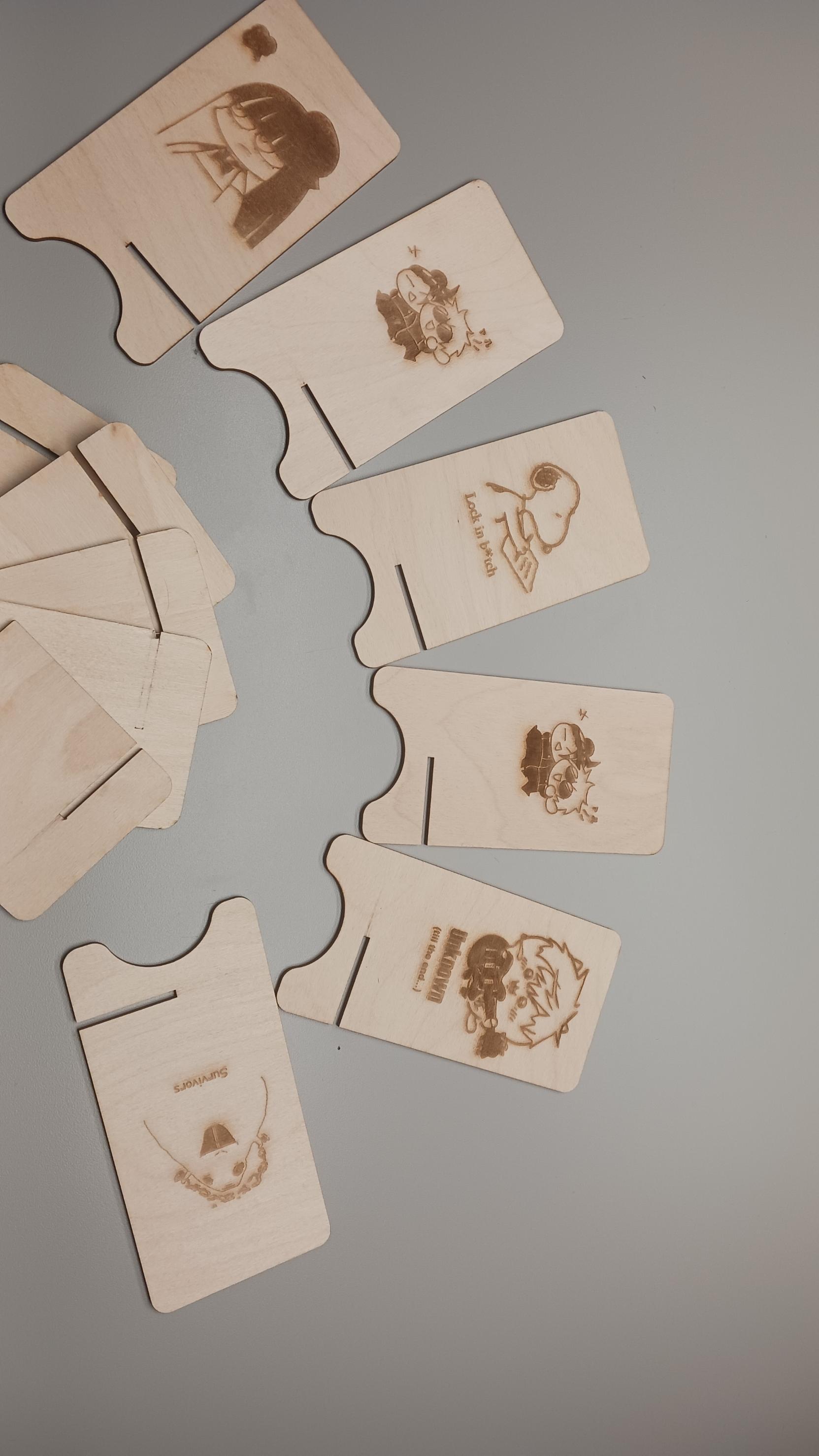 A closeup of the phone stand designs after being printed out and cut on the wood.