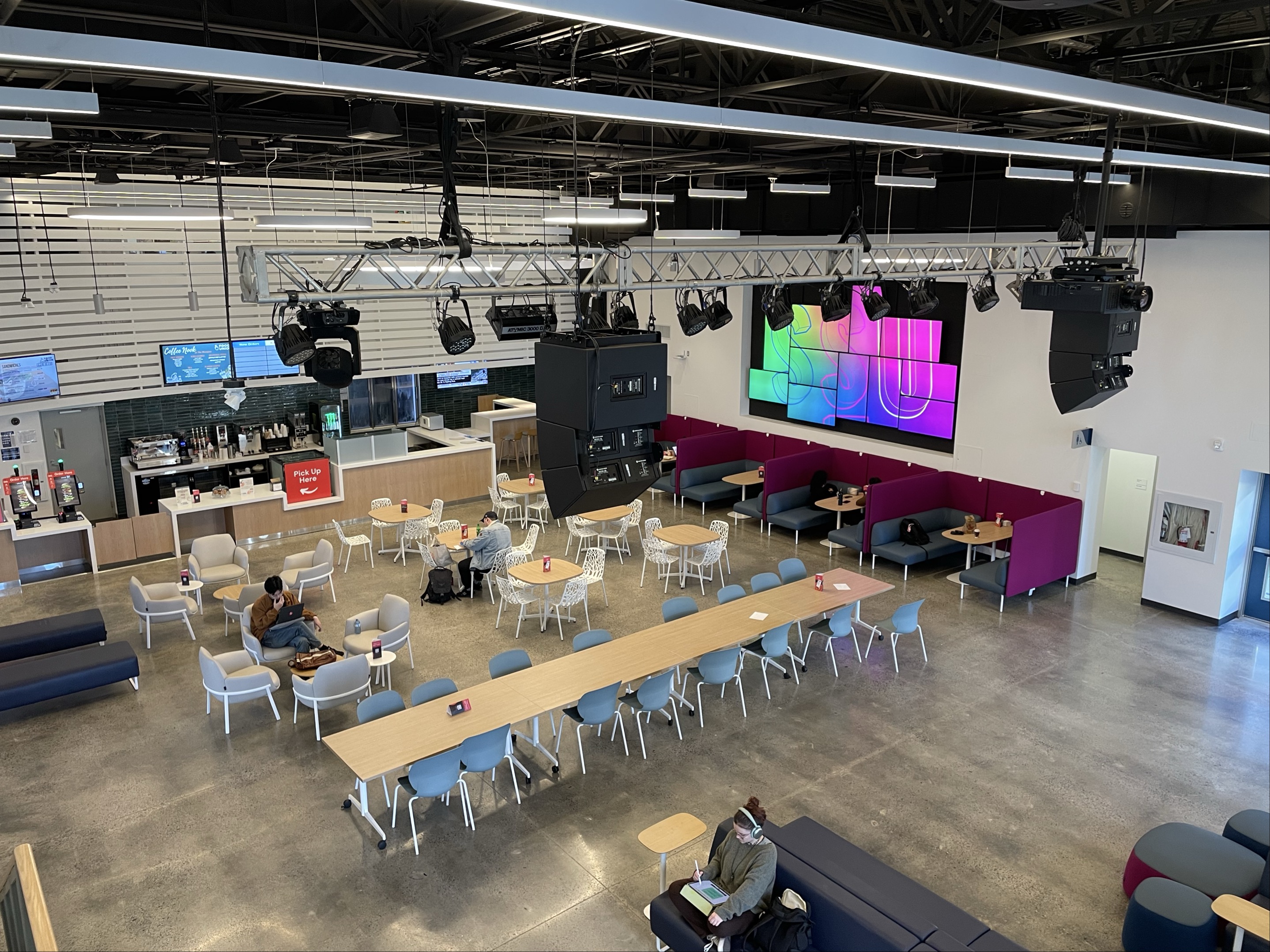 This is the marquee placed inside the student center. It's used as an area to eat, order food, lounge in, or study in. It appears materials such as various fabrics, stone floors, wood, and metal were used to contruct the area.
